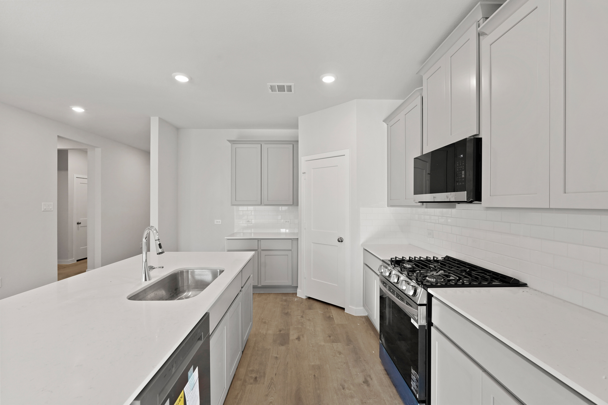 A kitchen with white cabinets.