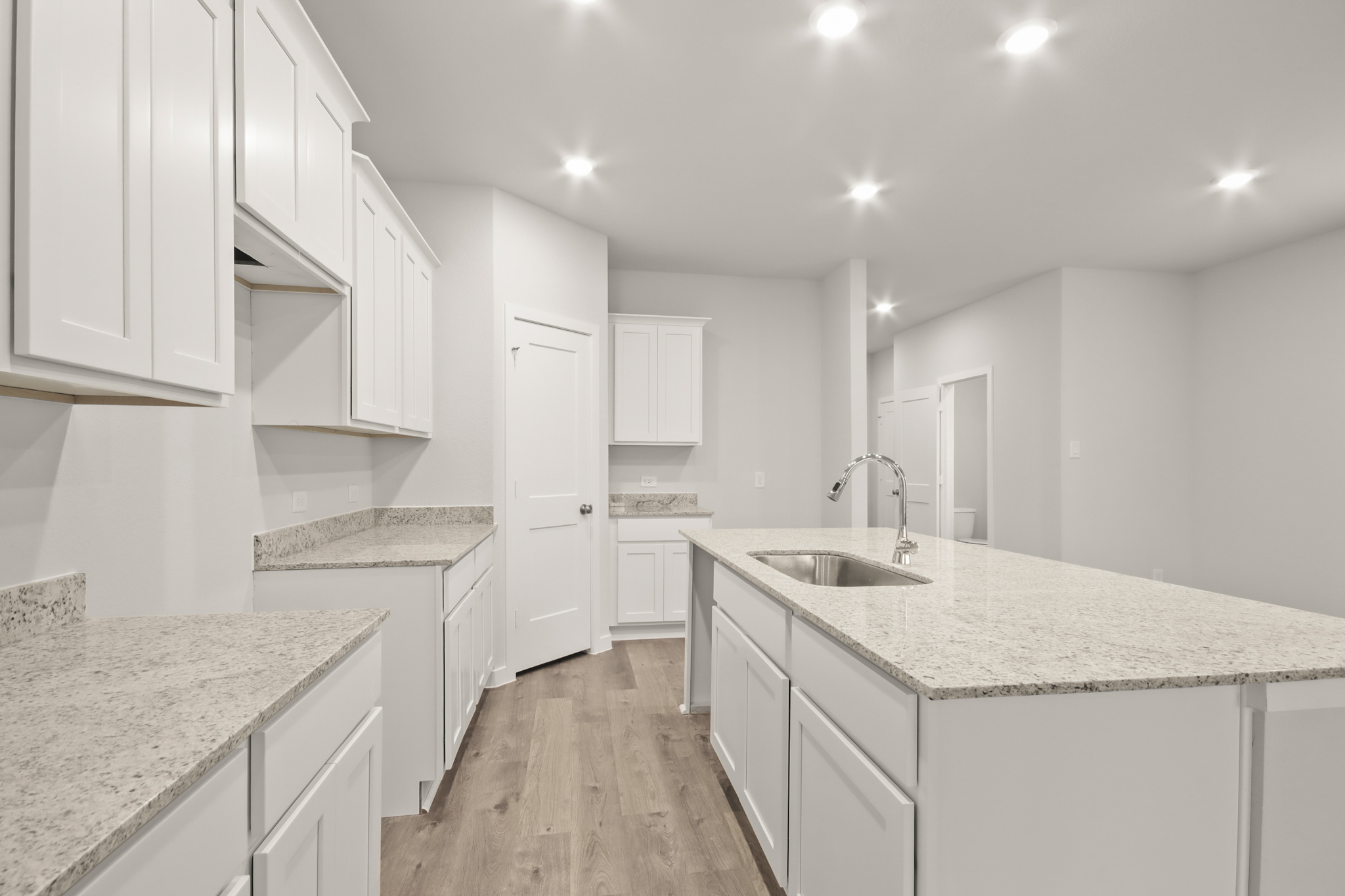 A kitchen with white cabinets.
