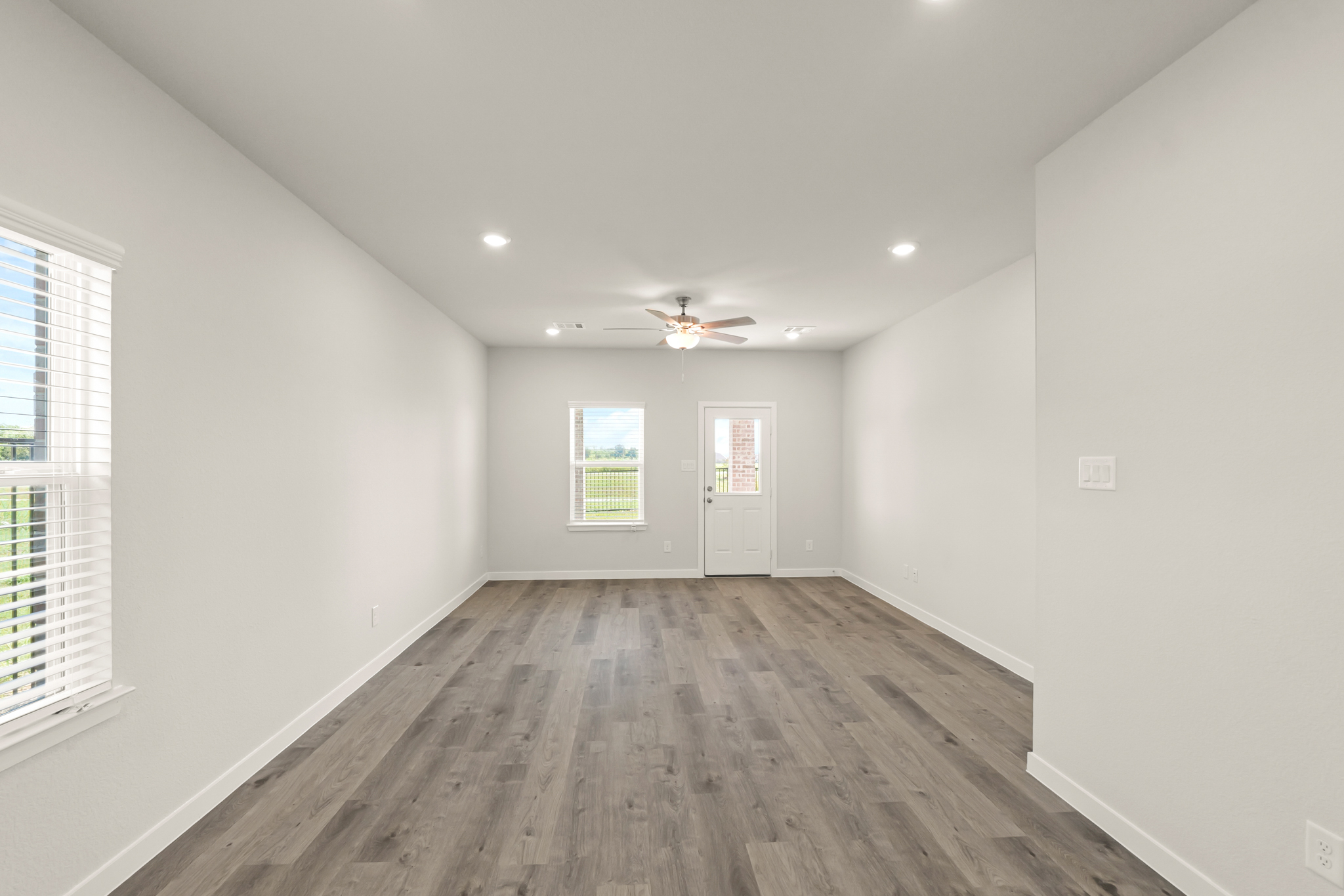 A room with a wood floor and a ceiling fan.