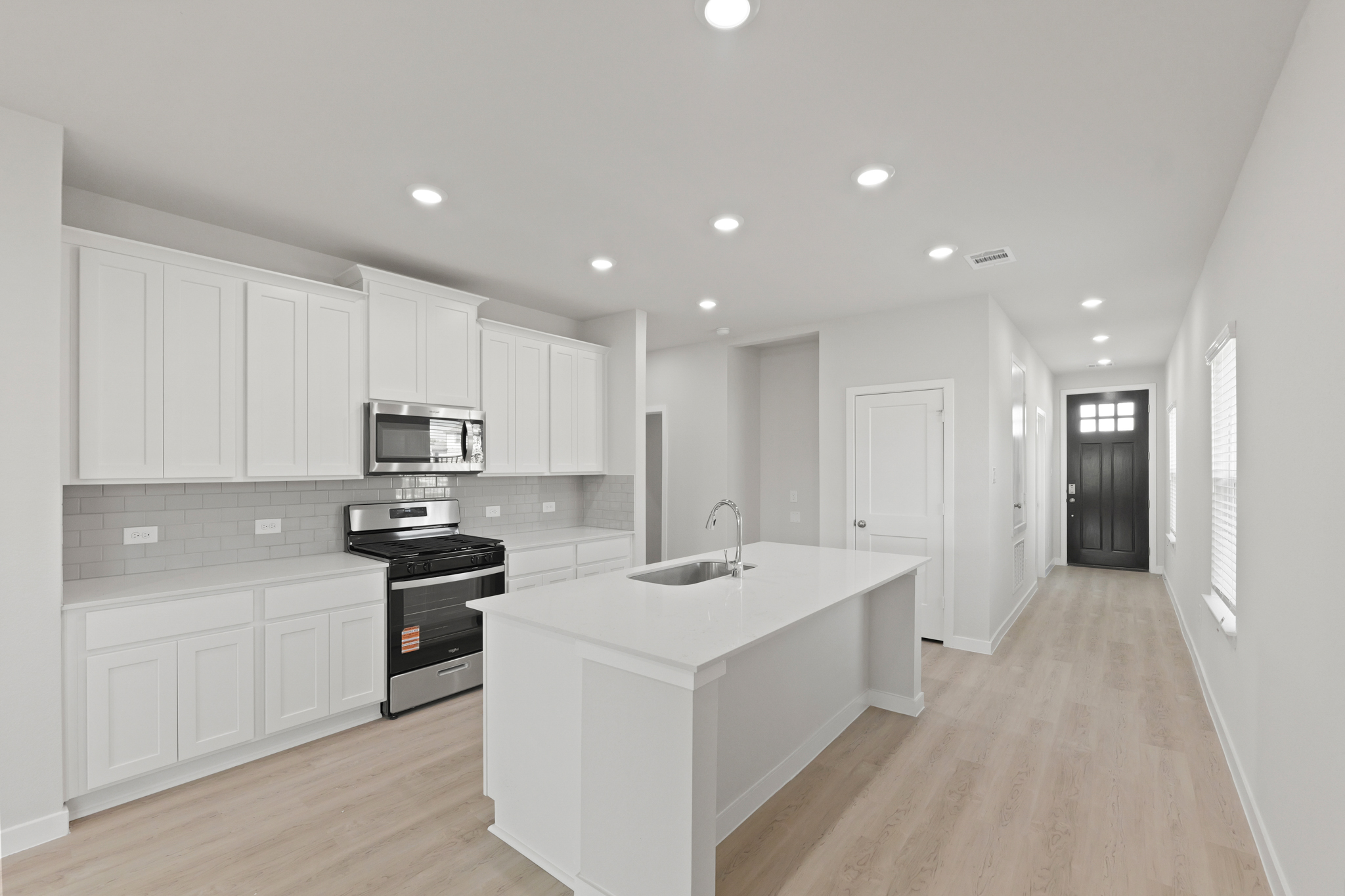 A kitchen with white cabinets.