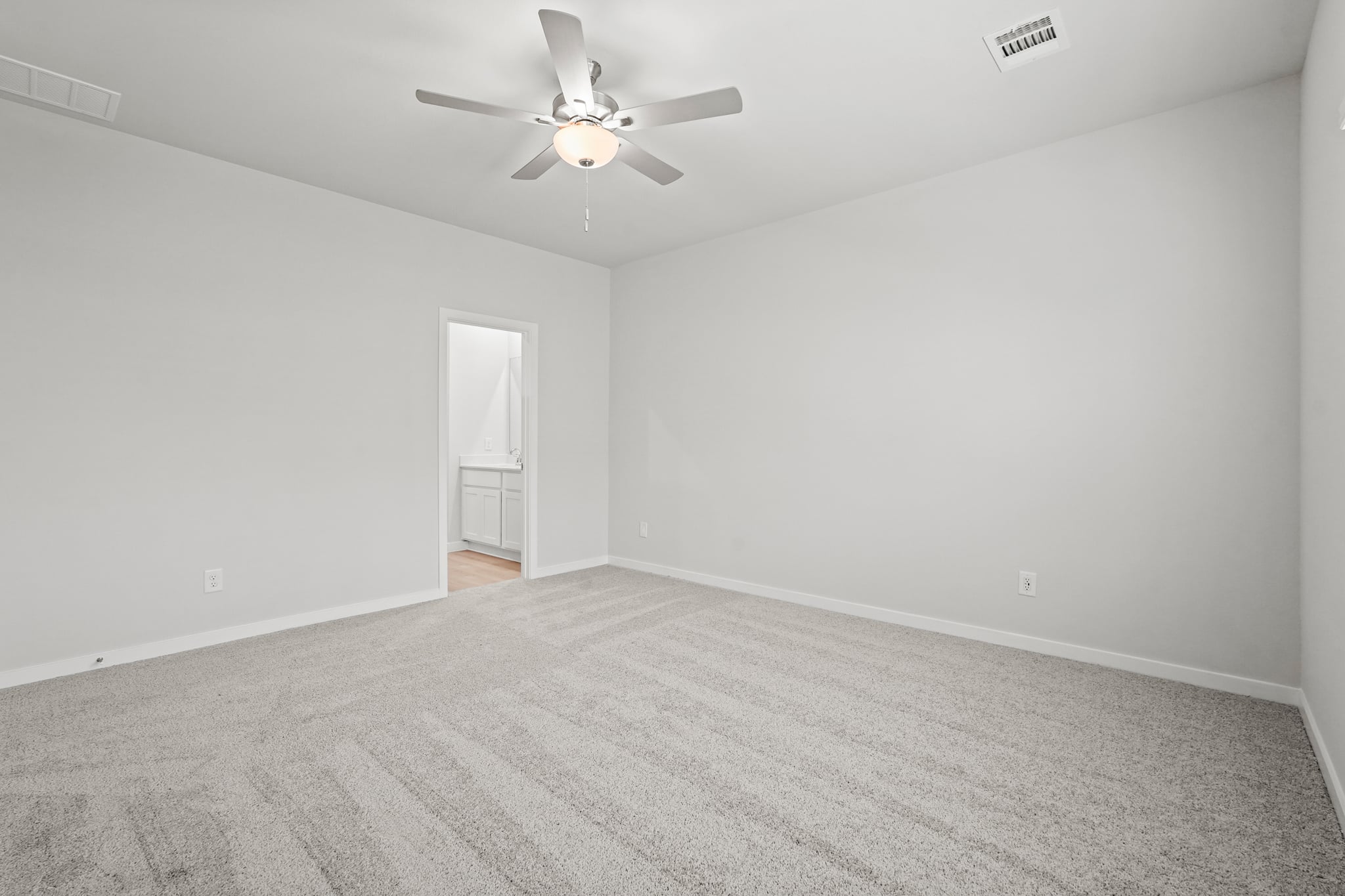 A room with a ceiling fan and a door.