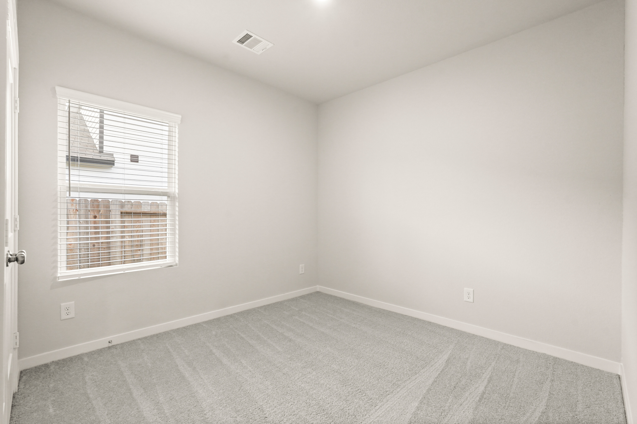 A room with a window and a rug.