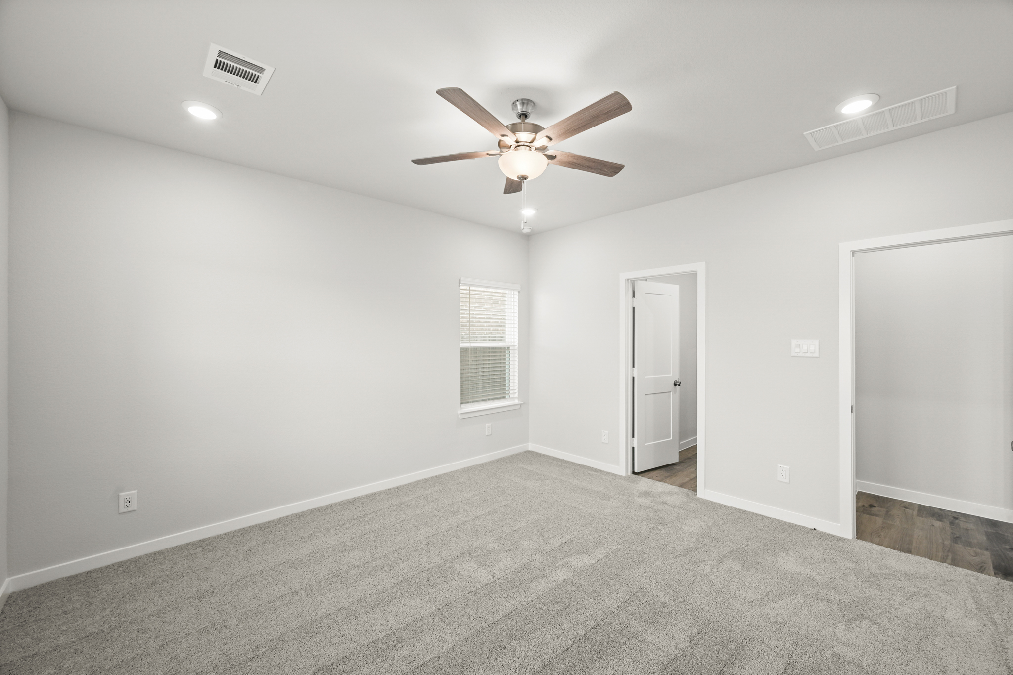 A room with a ceiling fan and a door.
