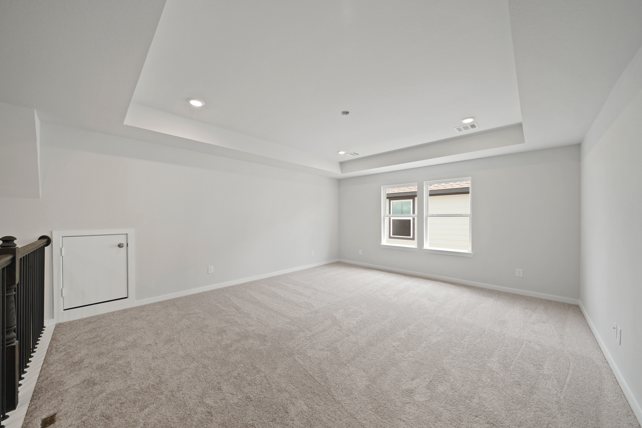 A room with a carpet and windows.