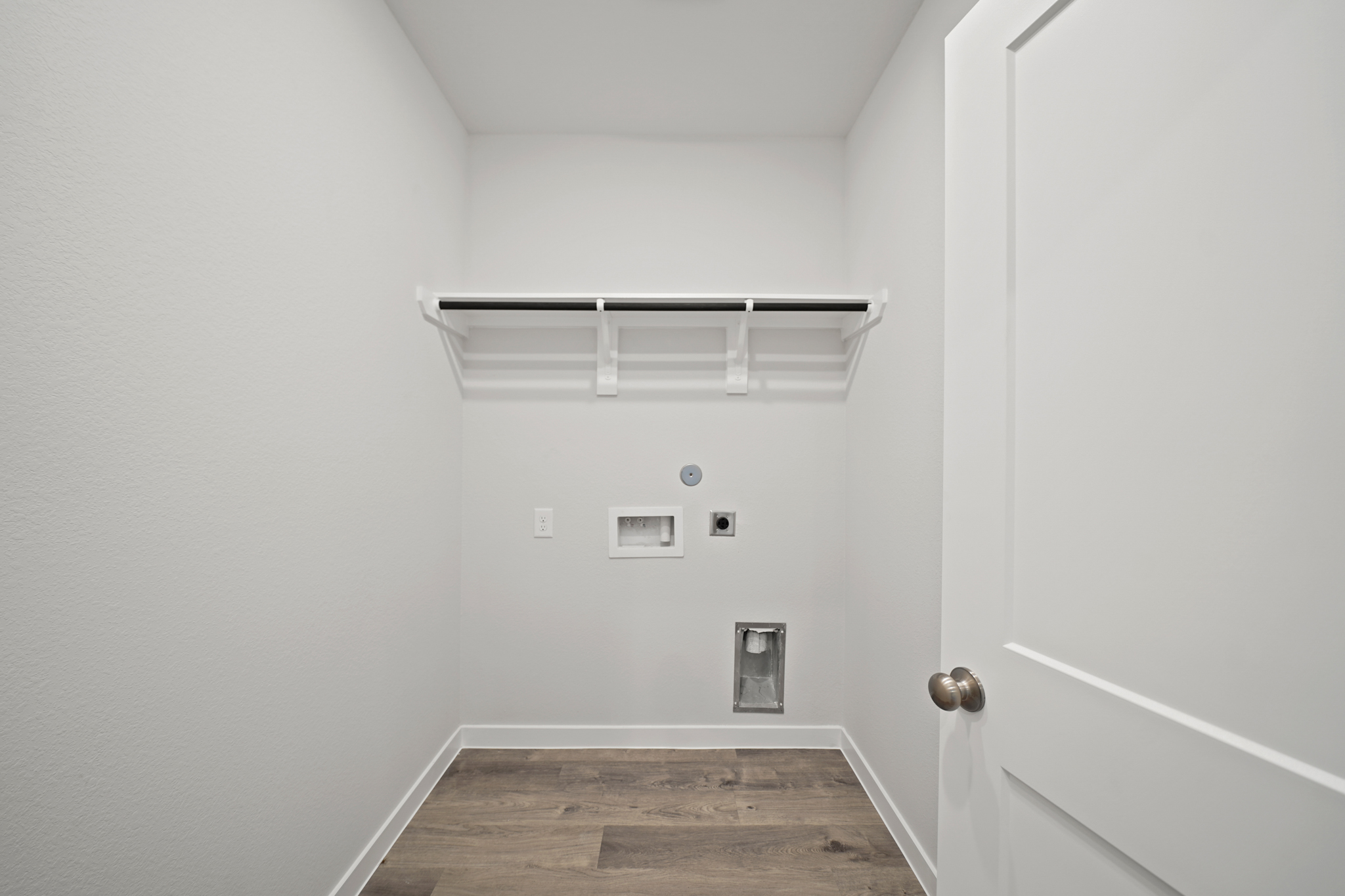 A room with a wood floor and a white door.