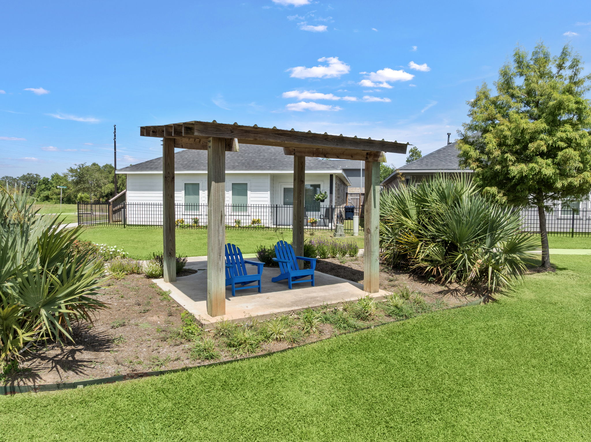 A gazebo with chairs and a pool in a yard.