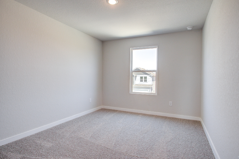 A room with a window and carpet.