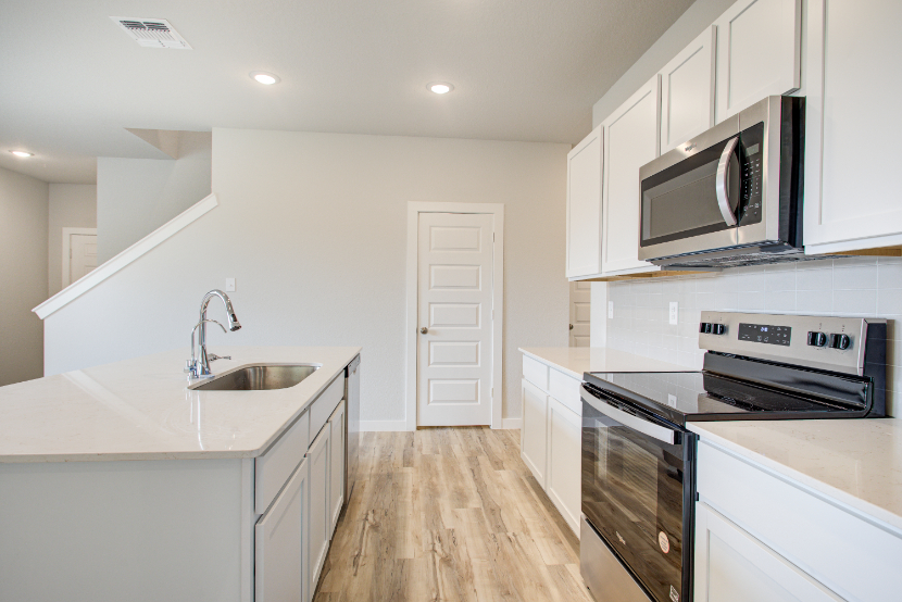 A kitchen with white cabinets.