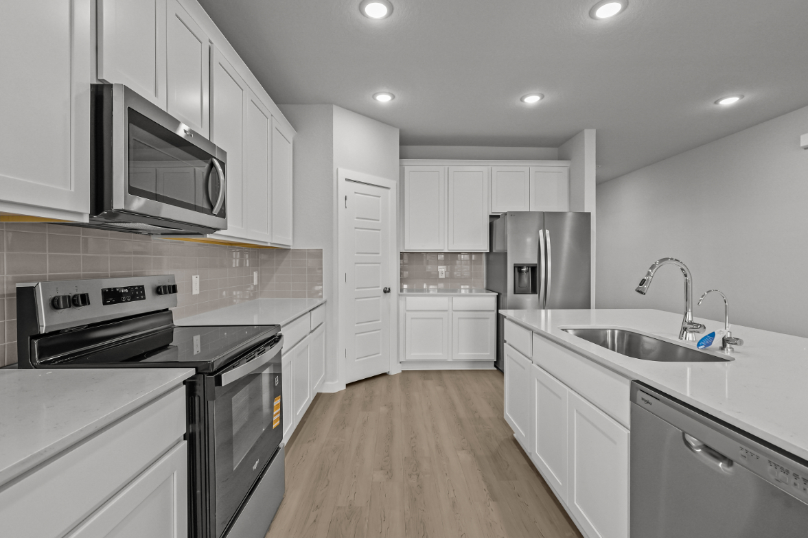 A kitchen with white cabinets.