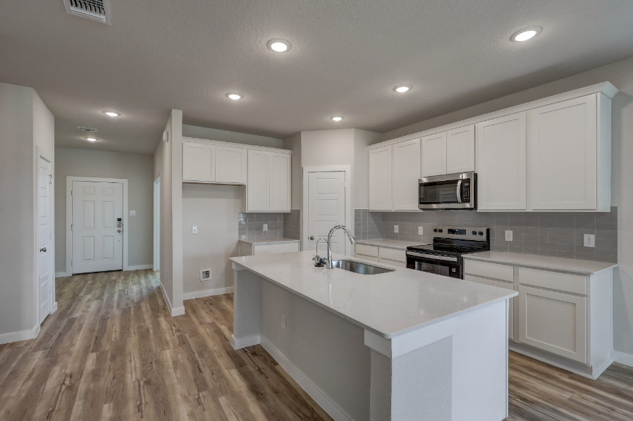 A kitchen with white cabinets.
