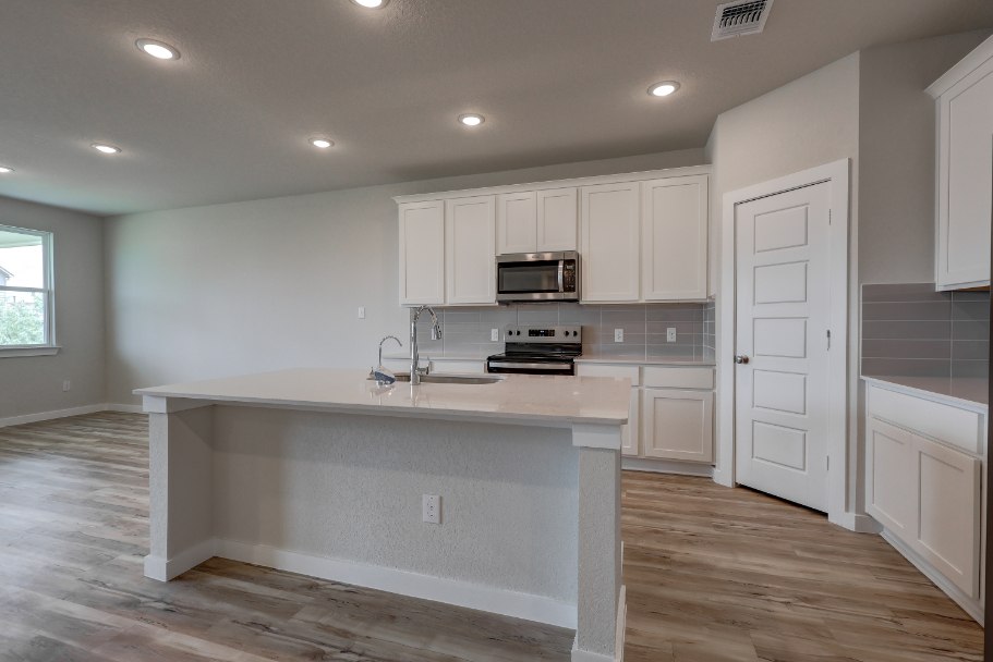 A kitchen with white cabinets.