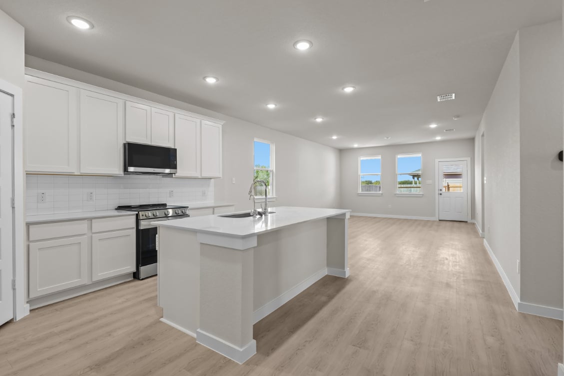 A kitchen with white cabinets.