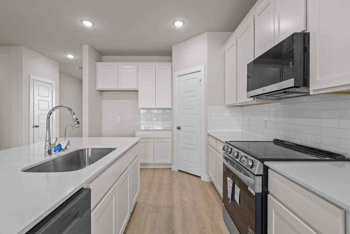 A kitchen with white cabinets.