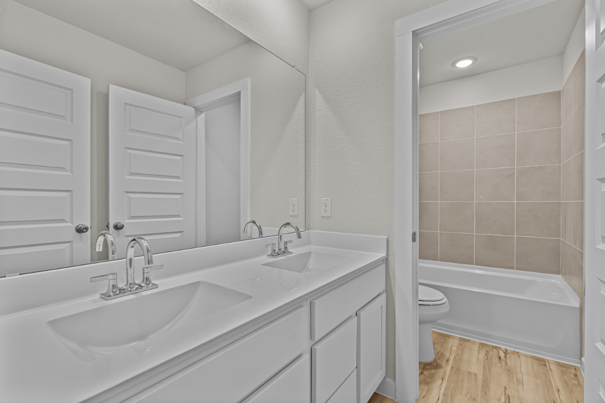 A bathroom with a tub sink and toilet.