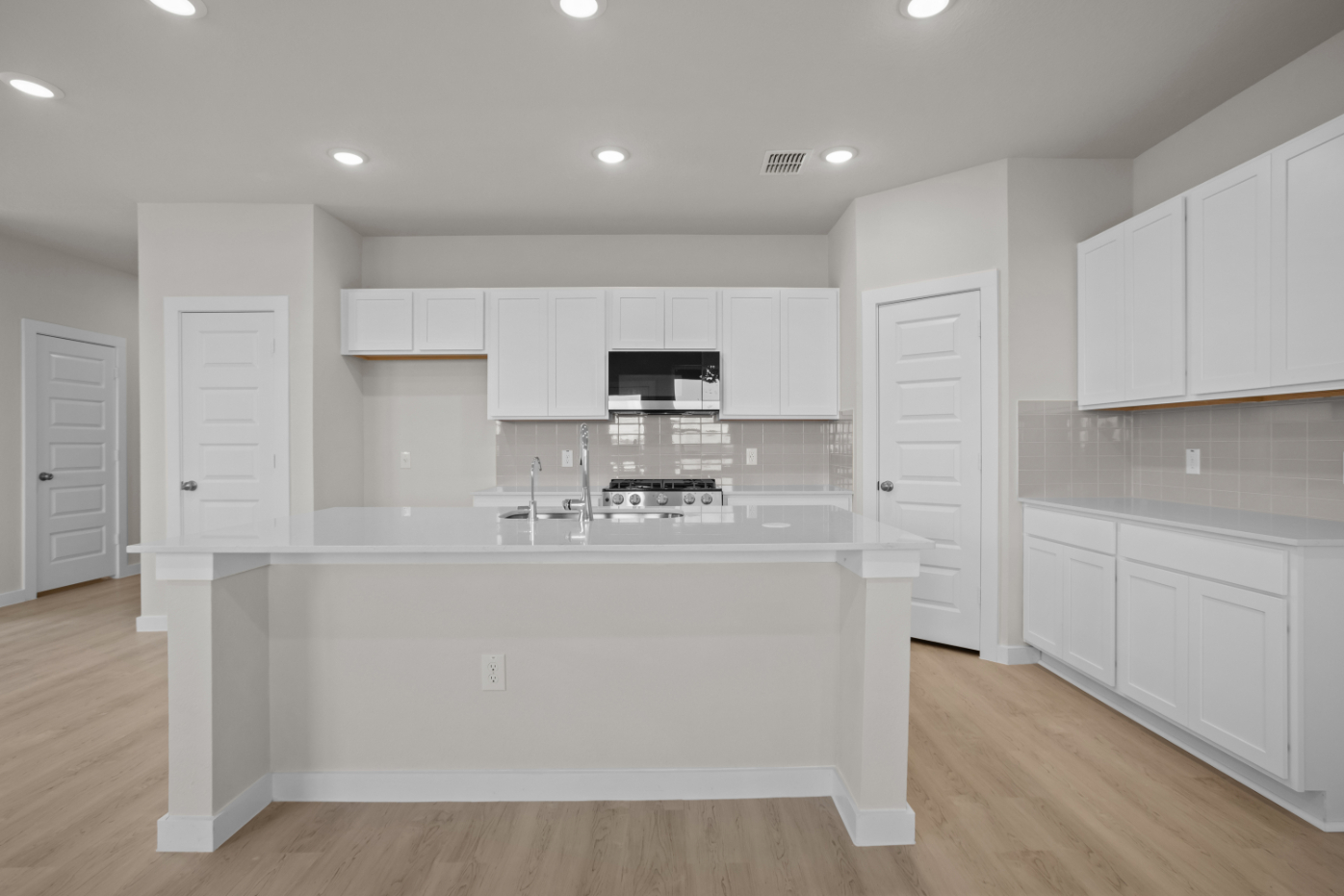 A kitchen with white cabinets.