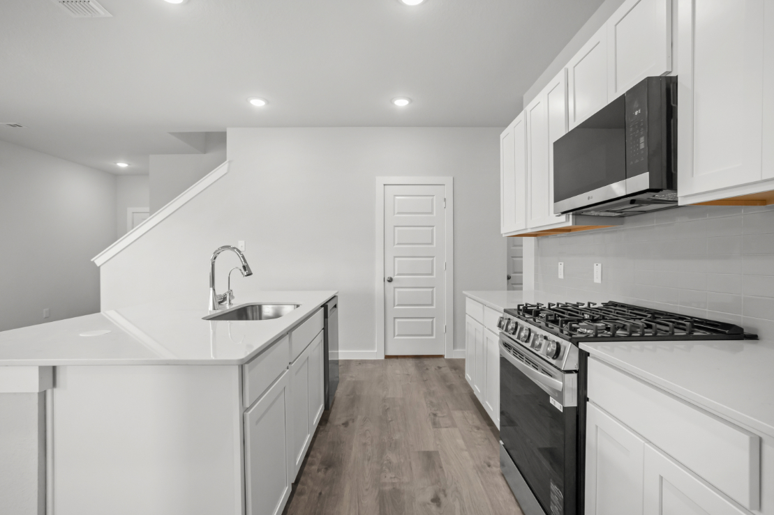 A kitchen with white cabinets.