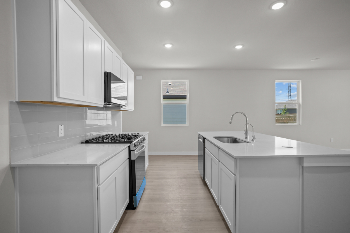 A kitchen with white cabinets.