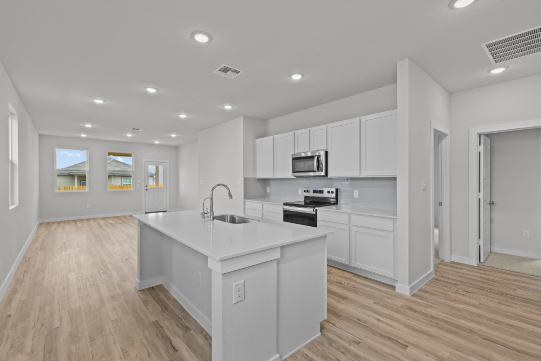 A kitchen with white cabinets.