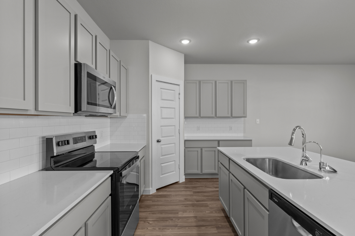 A kitchen with white cabinets.