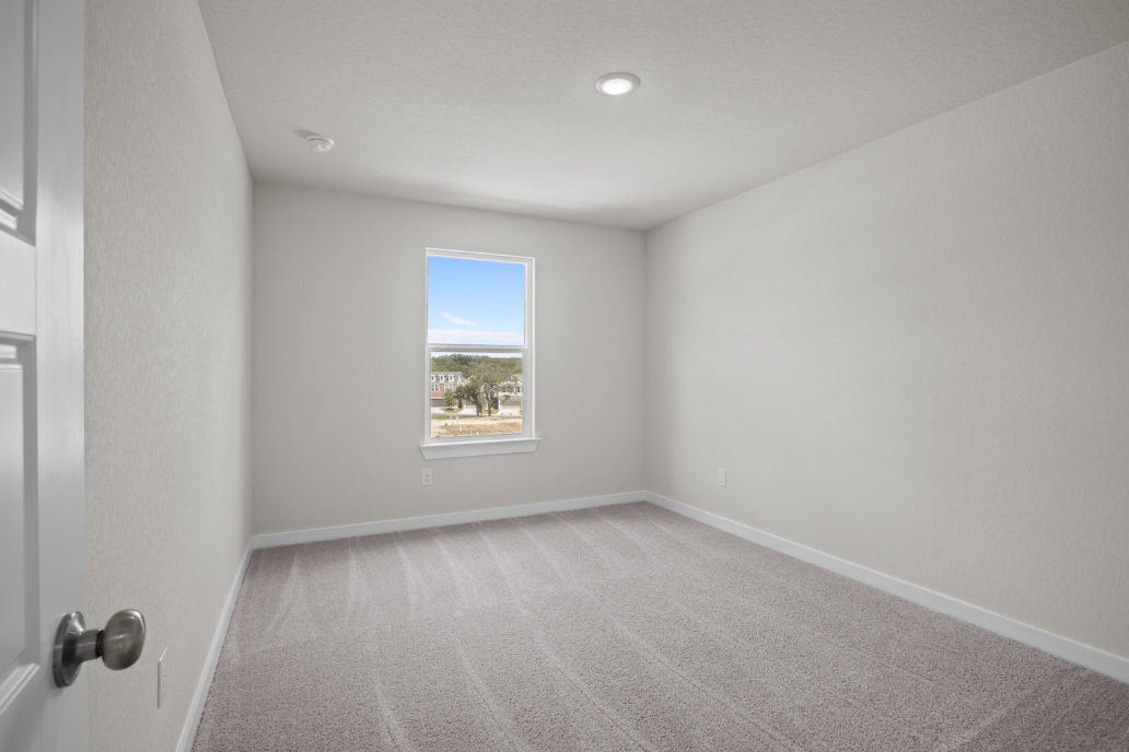 A room with a window and a carpet.