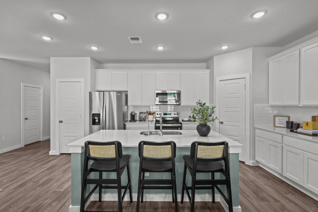 A kitchen with white cabinets.