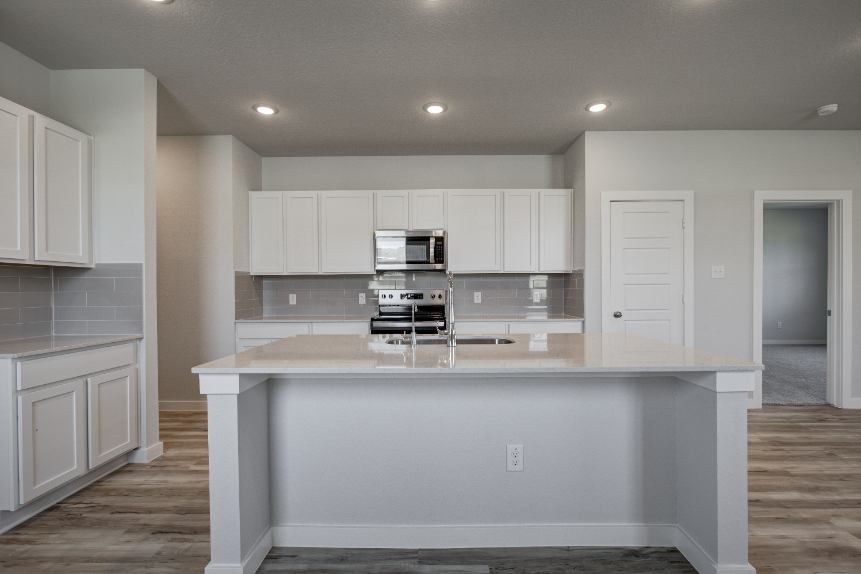 A kitchen with white cabinets.