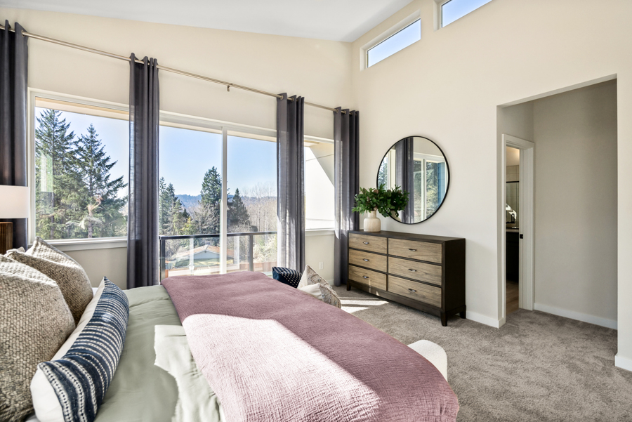 A bedroom with a large window.