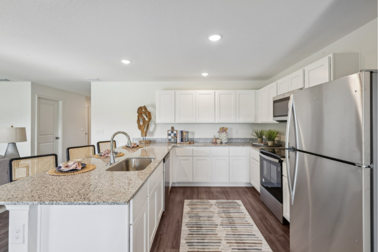 A kitchen with white cabinets.