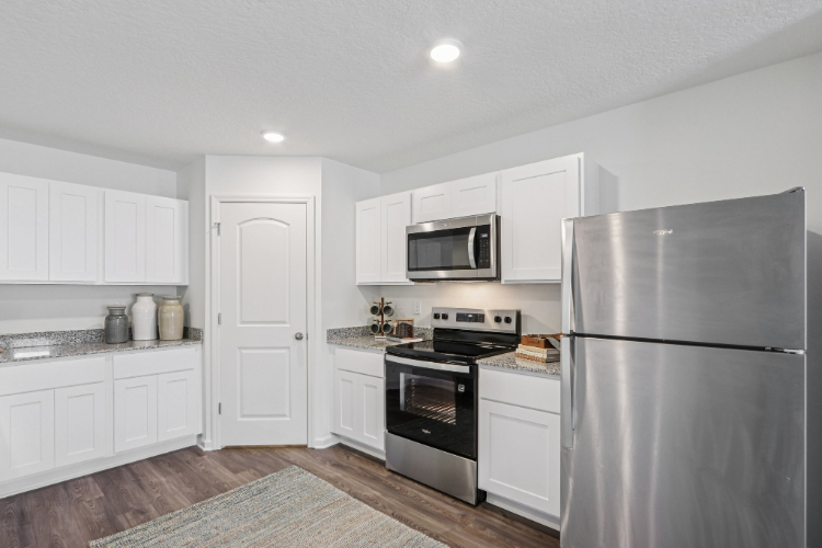 A kitchen with white cabinets.