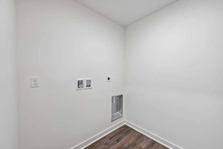 A white wall with a wood floor.