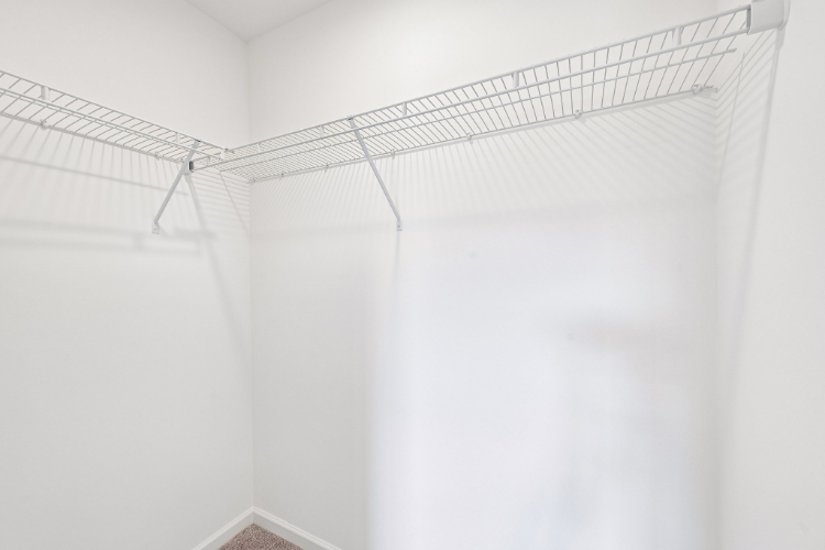 A white wall with a metal bar.