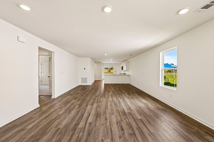 A long hallway with a wood floor.