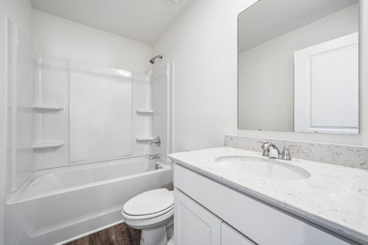 A bathroom with a tub sink and toilet.