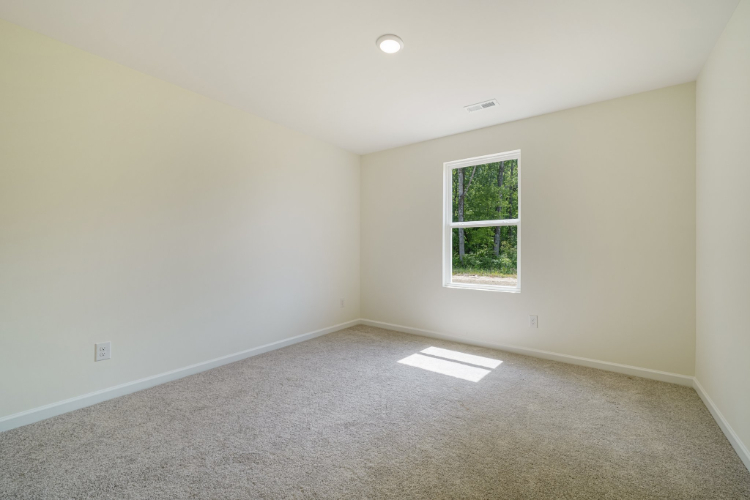 A room with a window and carpet.