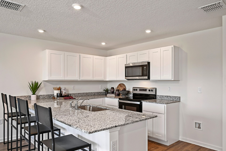 A kitchen with white cabinets.