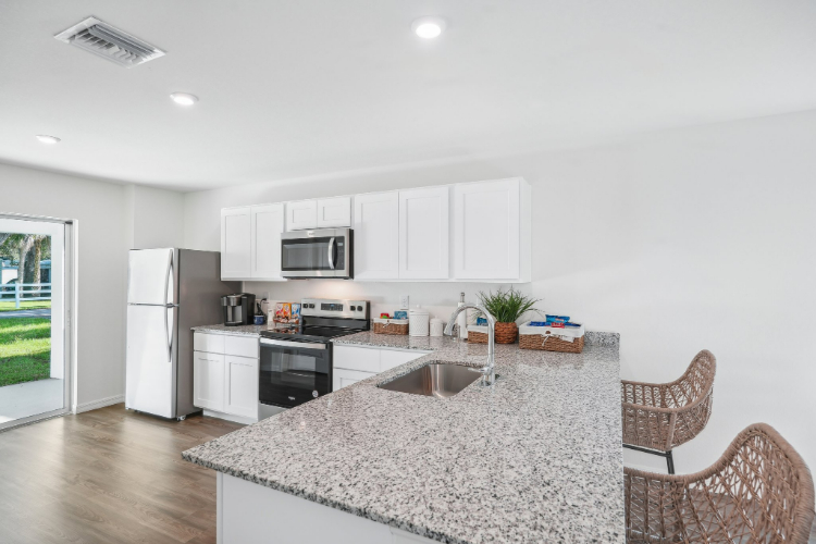 A kitchen with white cabinets.